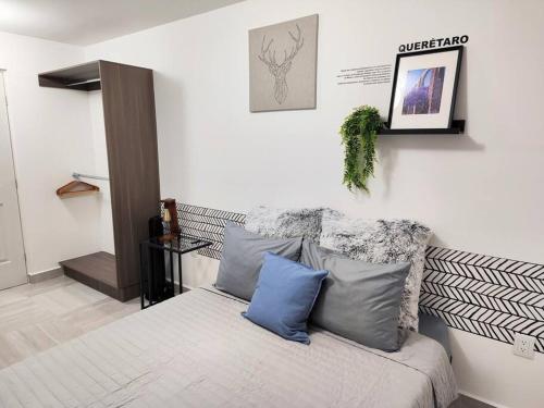 a bedroom with a bed with blue pillows on it at Departamento para 7 Personas 3 Recamaras Equipado in Buena Vista