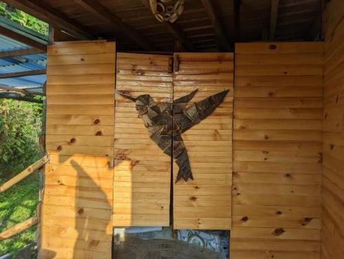 a painting of a bird on the side of a wooden wall at Habitación Colibrí, Pijao, Finca Flora del Río in Pijao