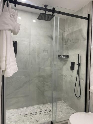 a shower with a glass door in a bathroom at Magnolias Suite in Lehigh Acres