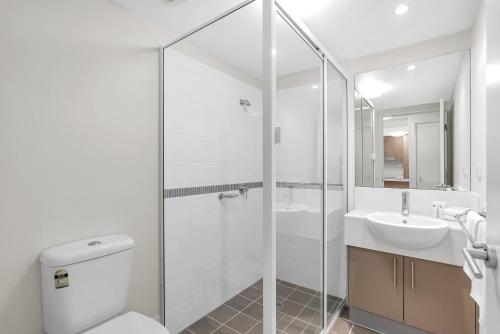 a white bathroom with a toilet and a sink at Botanical- Edge Hill Village in Edge Hill