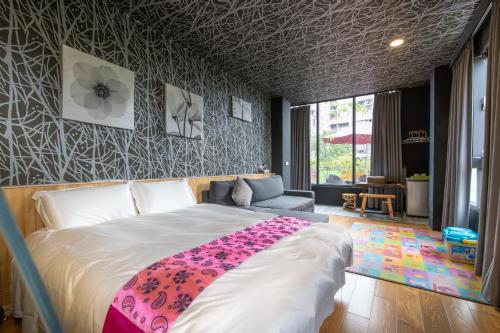 a bedroom with a large bed with a flower blanket on it at Yes Villa in Luodong
