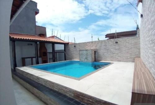 a swimming pool in the backyard of a house at Casa térrea com piscina e aconchegante perto da praia in Itanhaém
