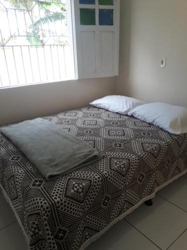een bed met een kussen erop in een slaapkamer bij Porto apartamento 6 in Porto Seguro