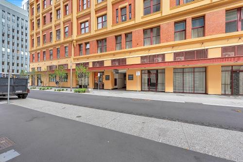 an empty street in front of a large building at Franklin Apartments in Adelaide