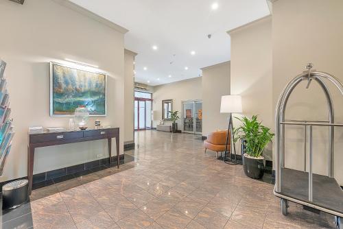 a lobby with a desk and a chair in a building at Franklin Apartments in Adelaide