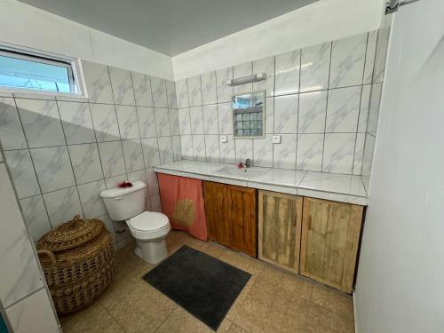 a bathroom with a toilet and a sink at Toamanahere Guesthouse in Tubuai