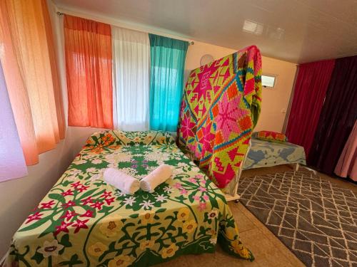 a bedroom with a bed and a chair in a room at Toamanahere Guesthouse in Tubuai