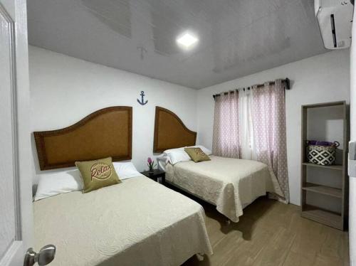 タルコレスにあるVilla Congo by Villas Oasis Guacalilloのベッド2台と鏡が備わるホテルルームです。