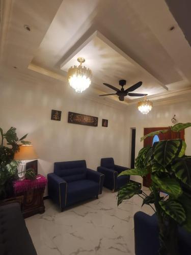 a living room with blue couches and a ceiling fan at DRS Legacy Homestay in Kamunting