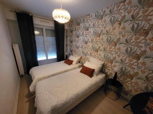 レ・サ​​ーブル・ドロンヌにあるAppartement Les Sables-d'Olonne, 3 pièces, 4 personnes - FR-1-92-622のベッドルーム1室(ベッド2台付)が備わります。壁紙を用いた内装です。
