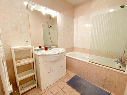 une salle de bain avec un lavabo et une baignoire dans l'établissement Appartement Charmant avec Garage à 400 m de la Plage - FR-1-92-738, à Les Sables-dʼOlonne