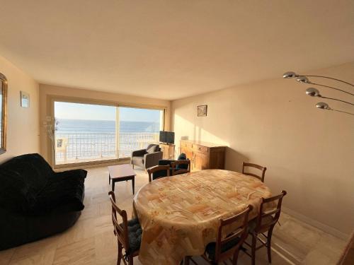 - un salon avec une table et une vue sur l'océan dans l'établissement Appartement 4 pièces avec balcon face mer, proche plage et commerces, idéal famillies - FR-1-197-199, à Les Sables-dʼOlonne