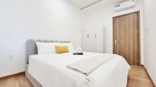 een slaapkamer met een groot wit bed en een houten vloer bij saigon riverside D1.V34-01 in Ho Chi Minh-stad