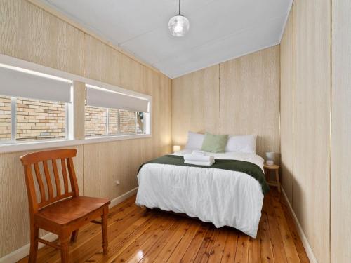 1 dormitorio con 1 cama, 1 silla y 1 ventana en Piper St Cottage, en Yarrawonga
