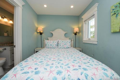 a bedroom with a large bed with a floral bedspread at Bayside Cutie at Bayside Bungalow in Anna Maria