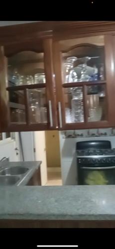 cocina con encimera y armarios con vajilla en Recidencial Albolera, en Cancino Adentro
