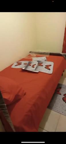 1 cama con edredón naranja en una habitación en Recidencial Albolera en Cancino Adentro