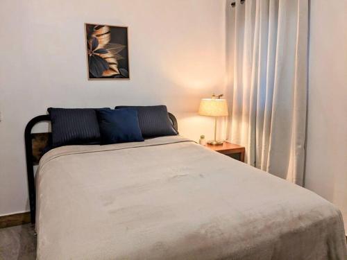 1 dormitorio con 1 cama y 1 mesa con lámpara en Estudio Bengala en San José del Cabo