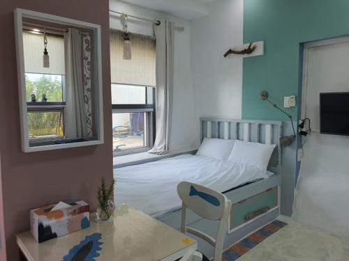 a small bedroom with a bed and a table and a chair at Jeju Mermuri in Seogwipo