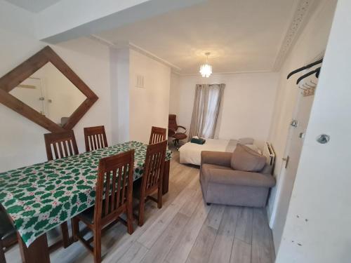 a room with a dining table and a bed and a couch at Three bedroom House in London