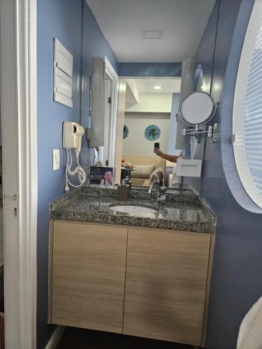 a bathroom with a sink and a mirror at Flat vista mar Boa Viagem in Recife