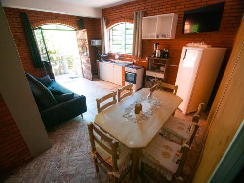 a kitchen with a table and chairs and a refrigerator at Residencial Colling in Canela