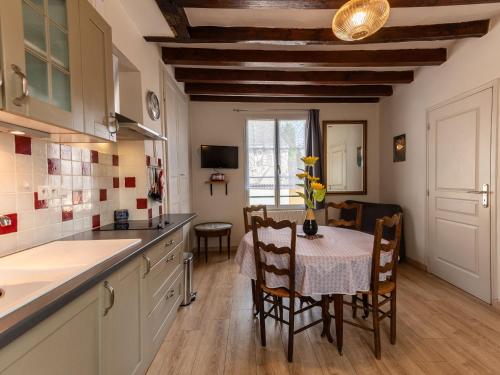 une cuisine et une salle à manger avec une table et des chaises dans l'établissement Charmant Gîte Confortable avec Wifi, au Cœur d'un Village Typique près de Bercé - FR-1-410-225, à Montreuil-le-Henri