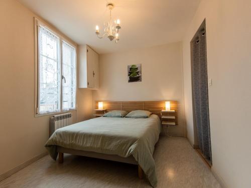 une chambre avec un lit, une fenêtre et un lustre dans l'établissement Charmant Gîte Confortable avec Wifi, au Cœur d'un Village Typique près de Bercé - FR-1-410-225, à Montreuil-le-Henri