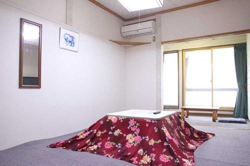een kamer met een tafel in het midden van een kamer bij ロッヂとんや in Seki
