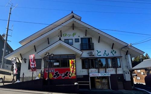una tienda frente a un edificio con graffiti en ロッヂとんや en Seki