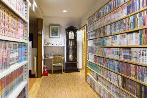 una biblioteca con pilas de libros en las paredes en ロッヂとんや, en Seki
