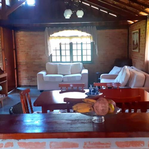 a living room with couches and a table with bananas on it at Casa em Visconde de Mauá in Visconde De Maua
