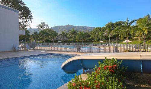 a swimming pool in a yard with mountains in the background at Apto Di Sole Santa FeAntioquia in Santa Fe de Antioquia