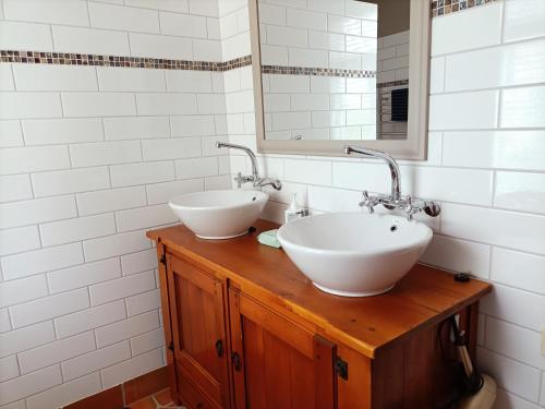 uma casa de banho com 2 lavatórios e um espelho em Connemara Country Lodge em Awhitu