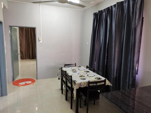 ein Esszimmer mit einem Tisch und einem schwarzen Vorhang in der Unterkunft RizqFateh Homestay in Keluang