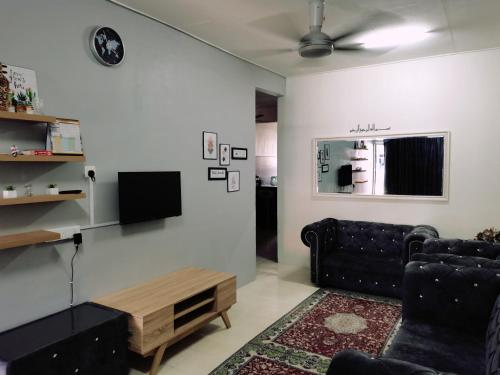 ein Wohnzimmer mit einem Sofa und einem TV in der Unterkunft RizqFateh Homestay in Keluang