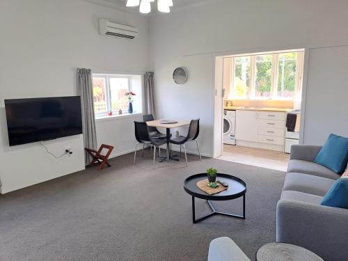 sala de estar con sofá y mesa en Surfers Dream - 1 bedroom en Dunedin