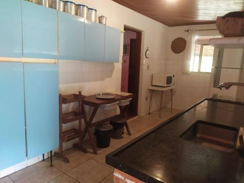 - une cuisine avec un évier et une table dans l'établissement Sítio Casarão, à Nazaré Paulista