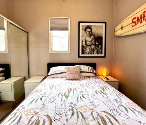 a bedroom with a bed and a surfboard on the wall at Zion in Sydney