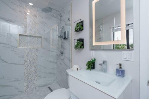 a white bathroom with a sink and a shower at New! Miami & Calle Ocho Simpson's Funhouse! in Miami