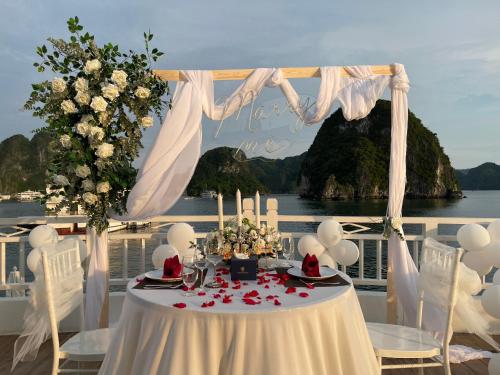 a table with candles and flowers on a balcony at Mila Cruises in Ha Long