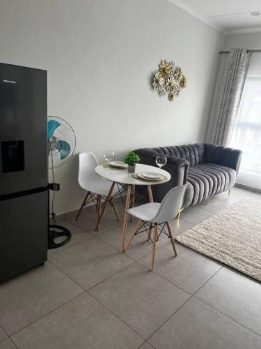 een woonkamer met een bank en een tafel en stoelen bij Crestline3 at Emeraldskye in Lombardy East