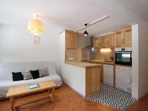 Cette petite chambre comprend un lit et une cuisine. dans l'établissement Charmant F2 bis au Mont-Dore avec balcon, au pied des pistes, 6 pers, parking, ascenseur - FR-1-415-150, à Le Mont-Dore