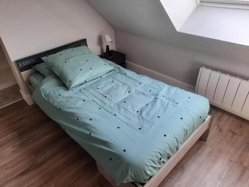 a bed with a blue comforter in a bedroom at Gîte spacieux avec grand jardin, à proximité de Vichy et attractions, tout confort inclus - FR-1-489-486 in Rongères