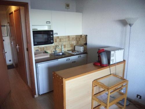 une petite cuisine avec un évier et un micro-ondes dans l'établissement Studio 4 pers au cœur des Orres 1650, accès direct pistes et commerces - FR-1-322-557, aux Orres