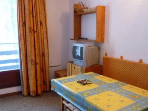 a room with a table and a tv in a room at Studio Les Orres, 1 pièce, 4 personnes - FR-1-322-570 in Les Orres