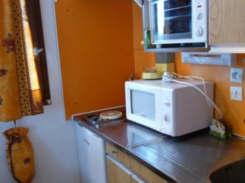 a kitchen with a microwave on top of a counter at Studio Les Orres, 1 pièce, 4 personnes - FR-1-322-570 in Les Orres