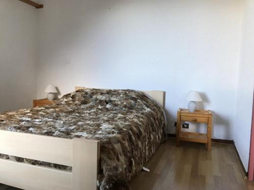 une chambre avec un grand lit et deux tables de nuit dans l'établissement T2 6 Pers au pied des pistes - Les Orres 1650 - FR-1-322-559, aux Orres