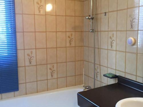 La salle de bains est pourvue d'une douche, d'une baignoire et d'un lavabo. dans l'établissement Appartement spacieux au pied des remontées, terrasse sud, 2 pièces, 6 personnes, accès direct aux pistes - FR-1-322-563, aux Orres