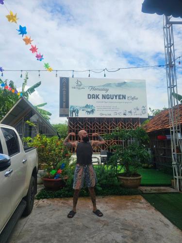 a man is standing in front of a sign at Dak Nguyen Homestay DakLak in Buon Ma Thuot